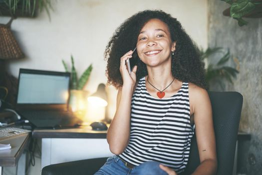 Shot of an attractive young woman sitting alone and using her cellphone to work from home stock photo