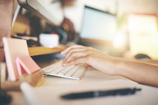 Cropped shot of an unrecognizable woman sitting alone and using her computer to work from home stock photo