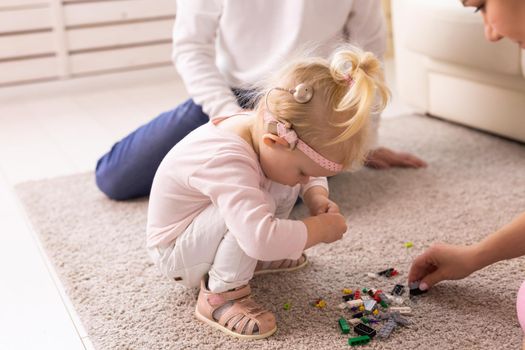 Cochlear implant on the child girl head and playing with mother and father. Hearing aid and deafness and innovative health technology