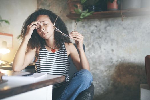Shot of an attractive young woman sitting alone and feeling stressed while working from home stock photo