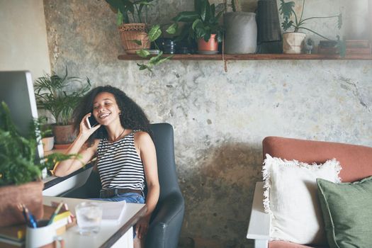 Shot of an attractive young woman sitting alone and using technology while working from home stock photo