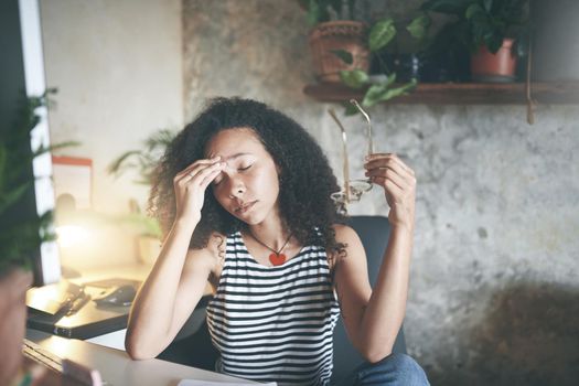 Shot of an attractive young woman sitting alone and feeling stressed while working from home stock photo