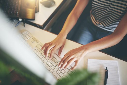 High angle shot of an unrecognizable woman sitting alone and using her computer to work from home stock photo