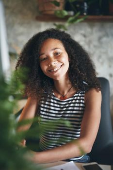 Shot of an attractive young african woman sitting alone and using her computer to work from home stock photo