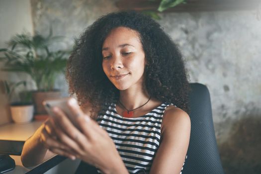 Shot of an attractive young woman sitting alone and using technology while working from home stock photo