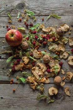 Dried delicious delicacies. Dry pieces of linden, rose hips, pears, raspberries, apples and walnuts snack on a wooden background.