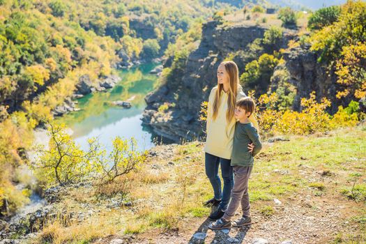 Montenegro. Mom and son tourists on the background of Clean clear turquoise water of river Moraca in green moraca canyon nature landscape. Travel around Montenegro concept.