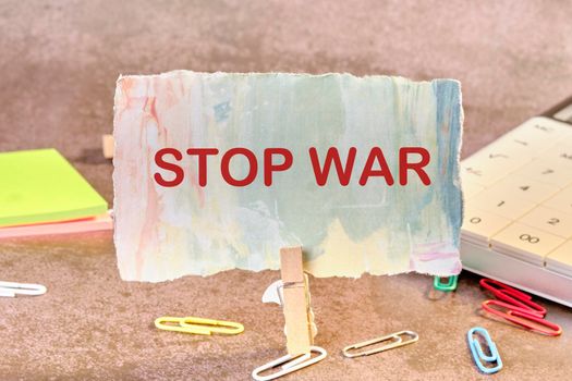 Stop the war text on a piece of paper secured with a clothespin.