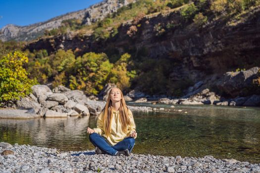 Montenegro. Woman tourist meditates on the background of Clean clear turquoise water of river Moraca in green moraca canyon nature landscape. Travel around Montenegro concept.