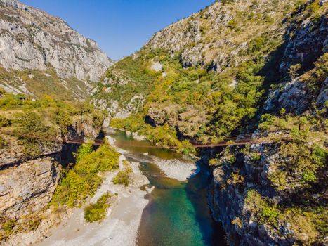 Sights of Montenegro. Landmark Old rusty bridge. Attraction Long extreme suspension iron bridge across the river Moraca. Montenegro.