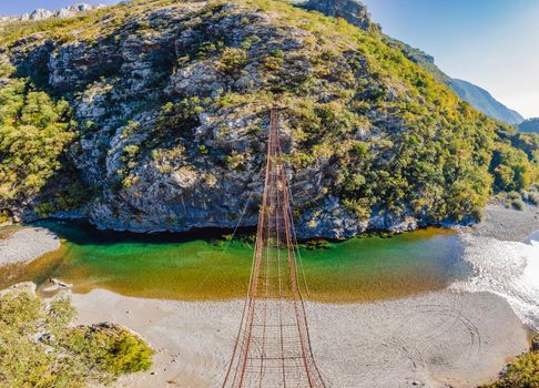 Sights of Montenegro. Landmark Old rusty bridge. Attraction Long extreme suspension iron bridge across the river Moraca. Montenegro.