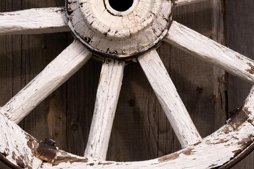 An old wooden carriage wheel hanging on the barn wall.