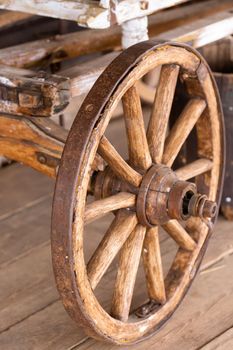 old wooden wheels are on the carriage at the ranch.