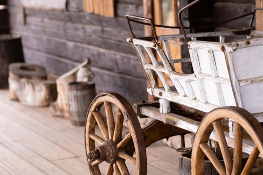 An empty antique carriage stands on a ranch in the wild West.