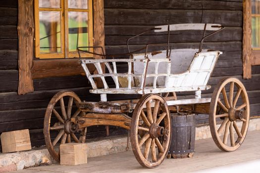 An empty antique carriage stands on a ranch in the wild West.