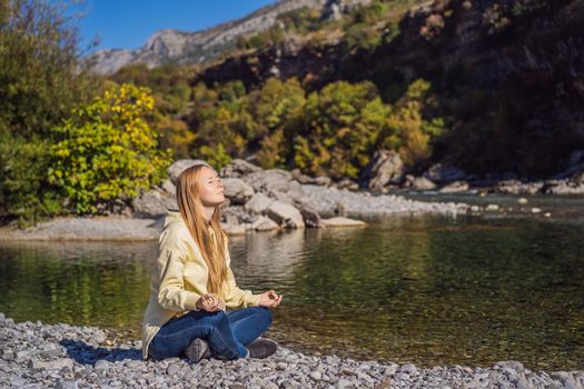 Montenegro. Woman tourist meditates on the background of Clean clear turquoise water of river Moraca in green moraca canyon nature landscape. Travel around Montenegro concept.