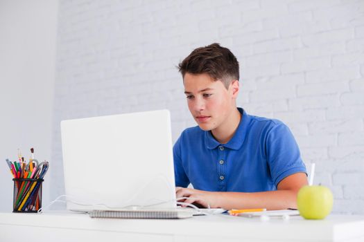 serious guy studying with laptop desk