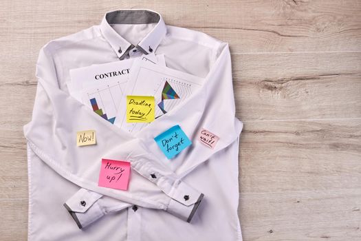 White shirt with sticky notes and business papers. Papers with motivation texts.