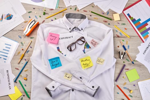 Top view flat lay white shirt and office stationery stuff. Paperclips with stapler and pens.