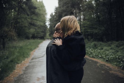 lovers hug in the forest in rainy weather