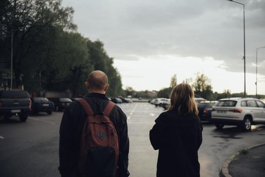 the lovers are coming. view from the back. the guy has a backpack on his back