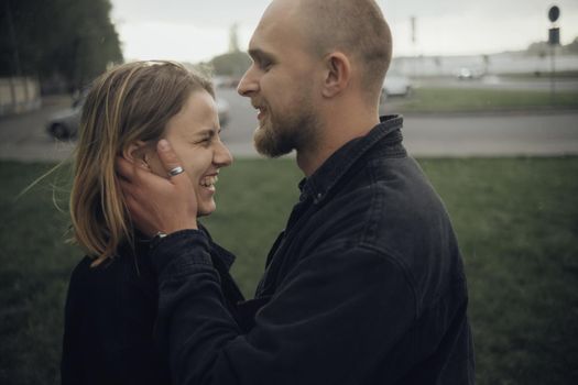 guy gently kisses his beloved holding hands on her face