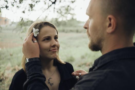 the guy places flowers in the hair of her beloved