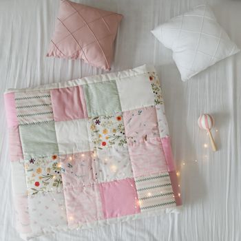 Cozy baby cot with a patchwork blanket. Baby bedding. Bedding and textile for nursery