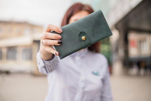 Sky blue handbag purse and beautiful woman hand with manicure. blurred background