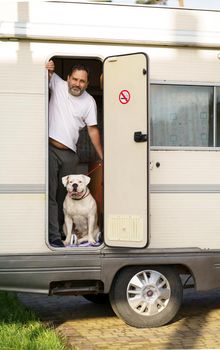 the concept of traveling in a motorhome. man traveling with dog