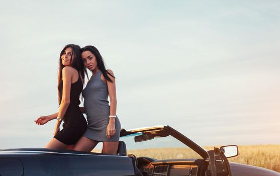 Two women in a black car on the roadside roads.