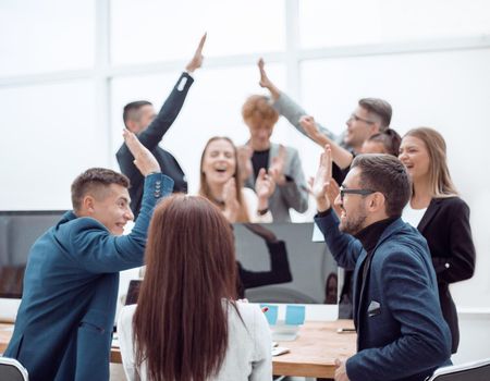 close up. a group of young business people giving each other a high five