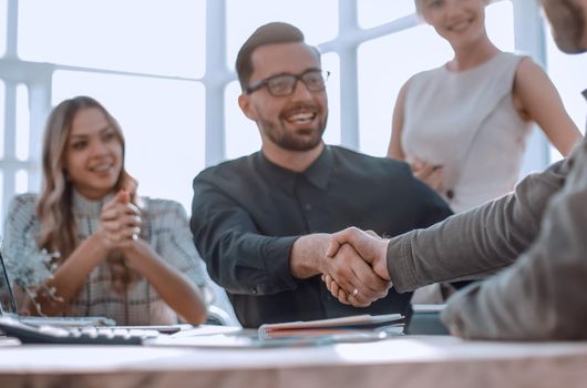 background image of the handshake of business partners in the office. business concept