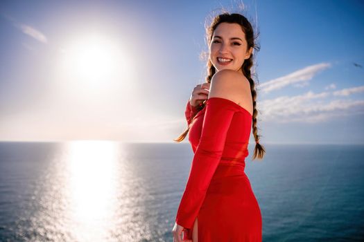 Closeup video portrait of sensual young brunette woman in red dress, happily dancing outdoors isolated on blurry sea background with natural bokeh in soft warm sunset backlight