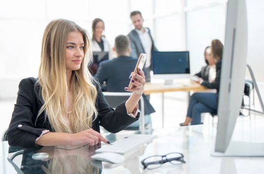 close up. young business woman using a smartphone in the workplace. people and technology