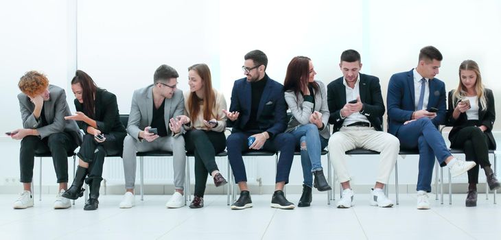 group of diverse young business people looking at their smartphone screens. photo with copy space