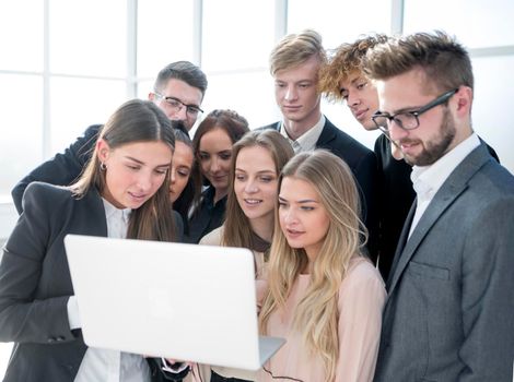 close up. a group of young employees looking at a laptop screen.