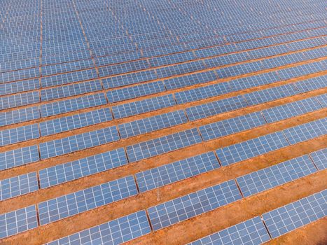 Aerial top view of a solar panels power plant. Photovoltaic solar panels at sunrise and sunset in countryside from above. Modern technology, climate care, earth saving, renewable energy concept