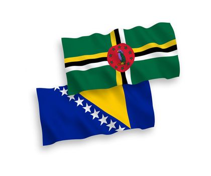 National fabric wave flags of Dominica and Bosnia and Herzegovina isolated on white background. 1 to 2 proportion.