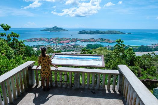 View point over the bay of Mahe to Eden Island,,Mahe Seychelles, a tropical beach with palm trees, and a blue ocean at Mahe Seychelles. woman at view point