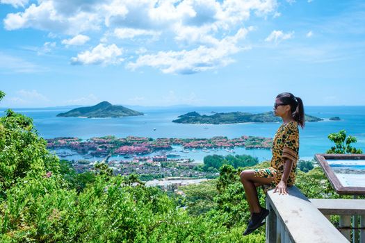 View point over the bay of Mahe to Eden Island,,Mahe Seychelles, a tropical beach with palm trees, and a blue ocean at Mahe Seychelles. woman at view point