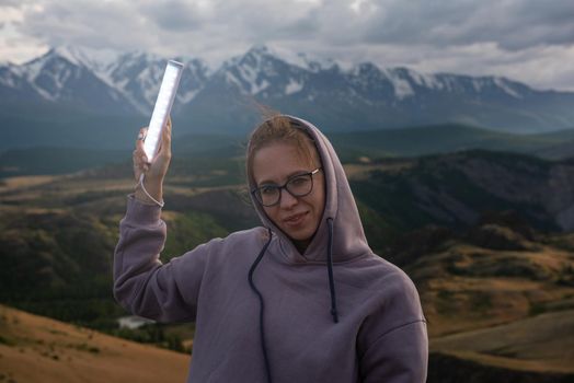 Woman with flashlight in summer Altai mountains in Kurai steppe