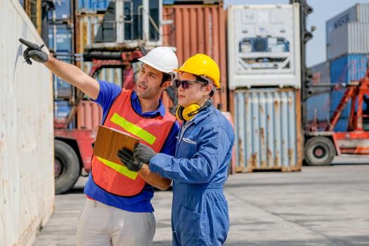 Technician and engineer work together for checking quality and product in cargo container shipping area.