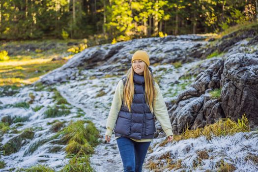 Young adult woman alone slowly walking after snowfall. Peaceful atmosphere in amazing awesome winter day. Enjoying fresh air in snowy forest trail.