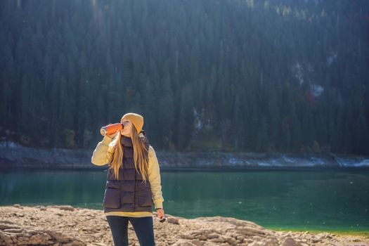 Woman tourist in background of Panoramic morning view of Black Lake Crno Jezero. Calm summer scene of Durmitor Nacionalni Park, Zabljak location, Montenegro, Europe. Beauty of nature concept background. Travel around Montenegro concept.
