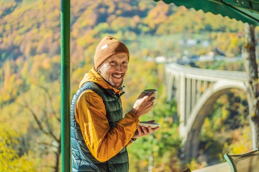 Montenegro. Man touriste in background of Dzhurdzhevich Bridge Over The River Tara foggy morning. Travel around Montenegro concept. Sights of Montenegro.