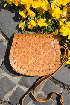 small yellow women's leather bag with a carved pattern. street photo