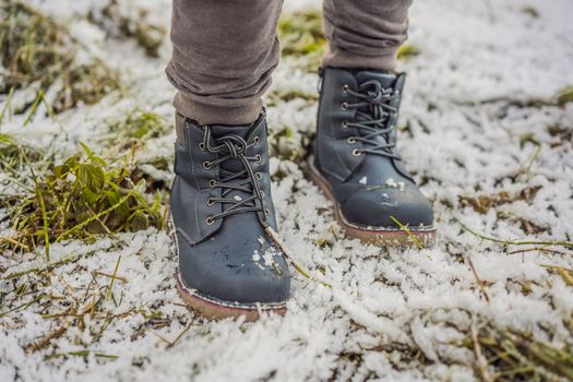 Children's blue hiking boots in the snow.