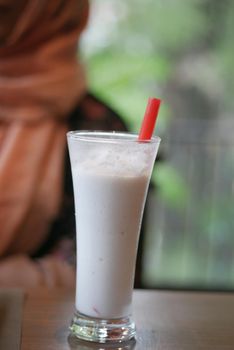 young women drinking banana milk shake at cafe .