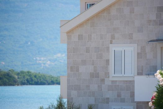 House window with white closed shutters.